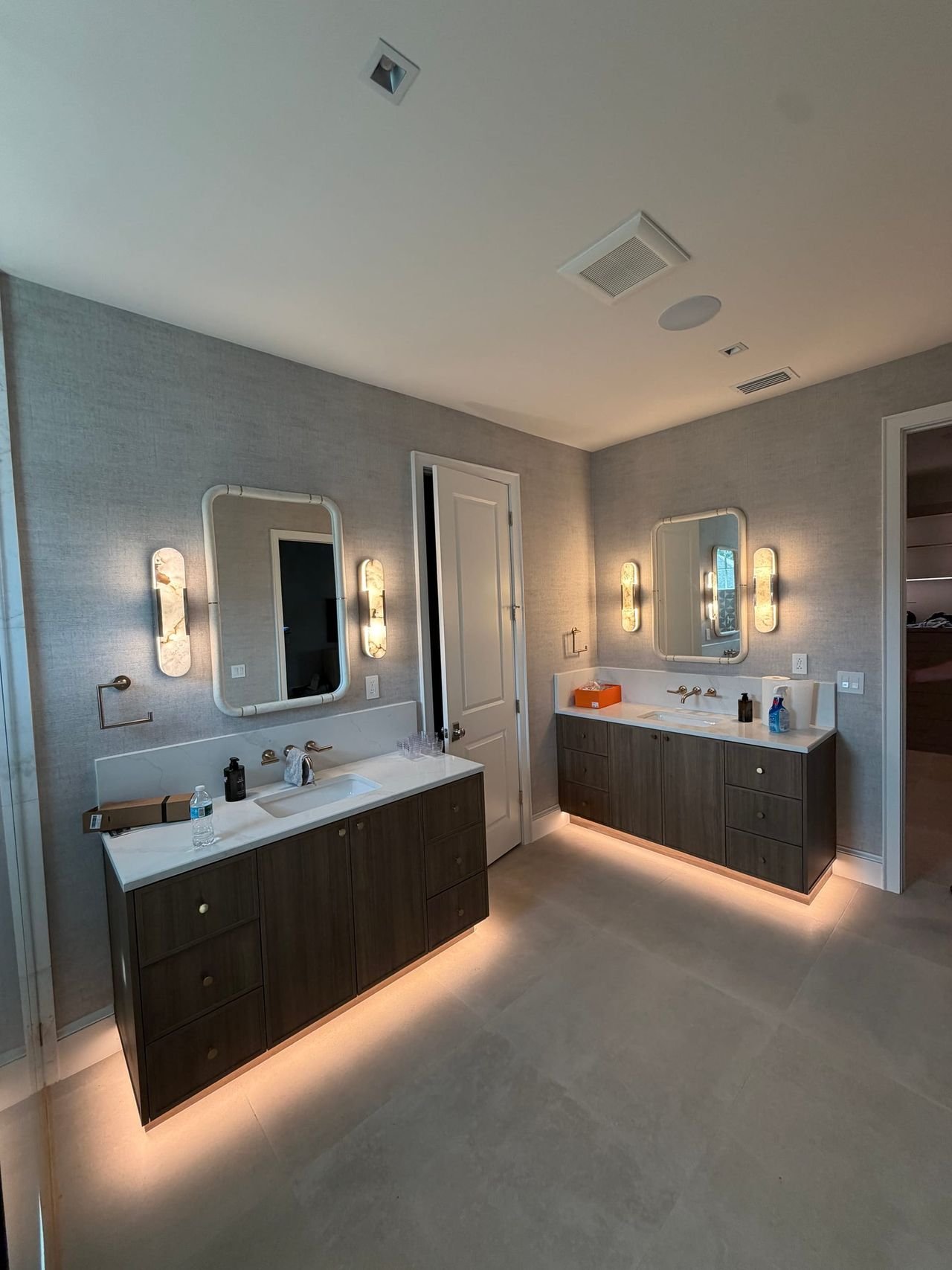 Primary bathroom with twin floating vanities and LED under-lighting