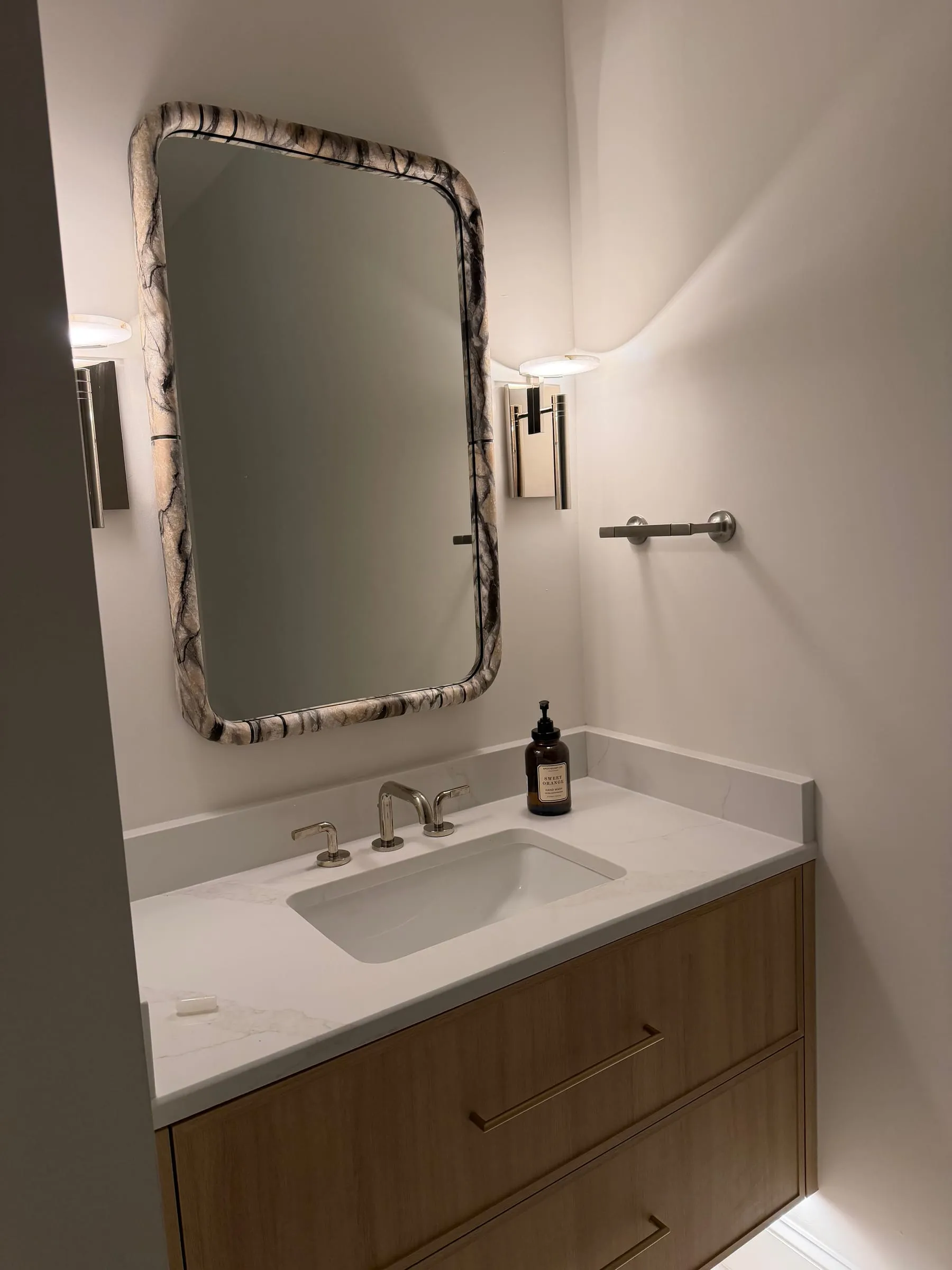 Bathroom vanity with stone top and arched mirror
