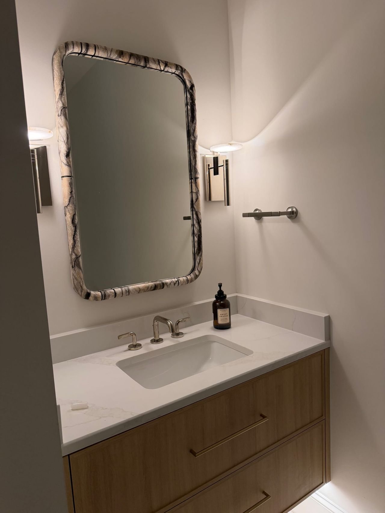 Bathroom vanity with stone top and arched mirror