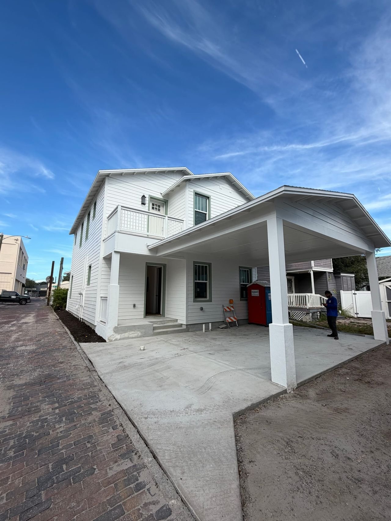 Custom home exterior with covered carport and paver drive