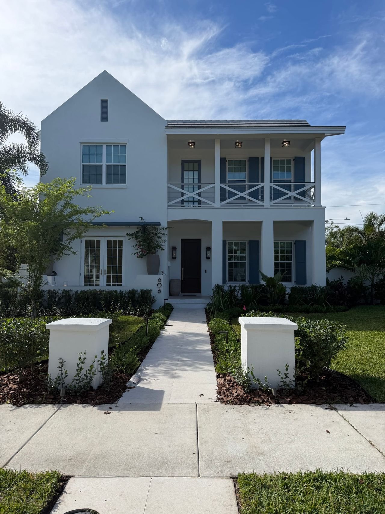 Two-story coastal custom home with double front porches, built by Palm Bay Construction Group