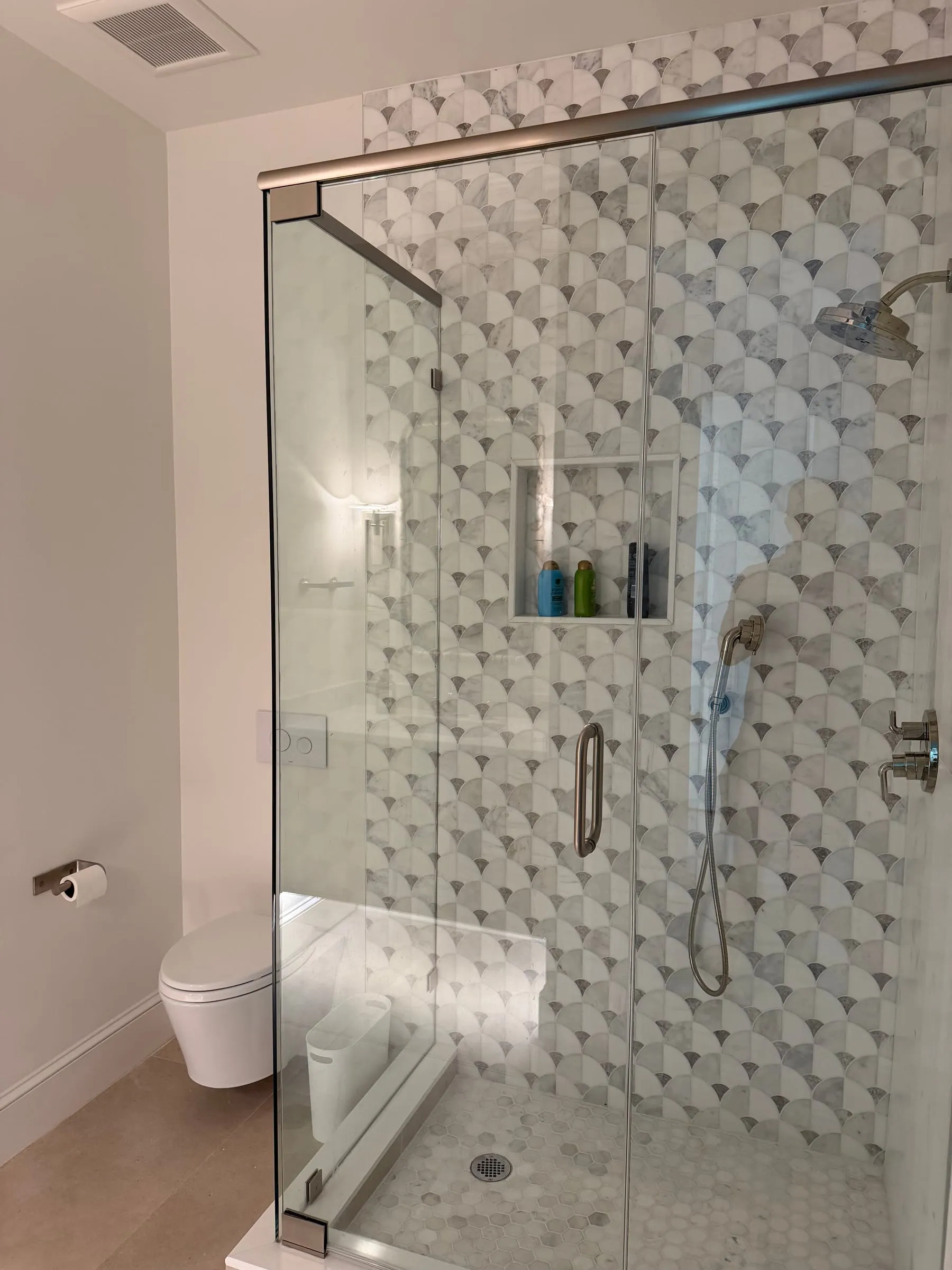 Frameless glass shower with dimensional white tile