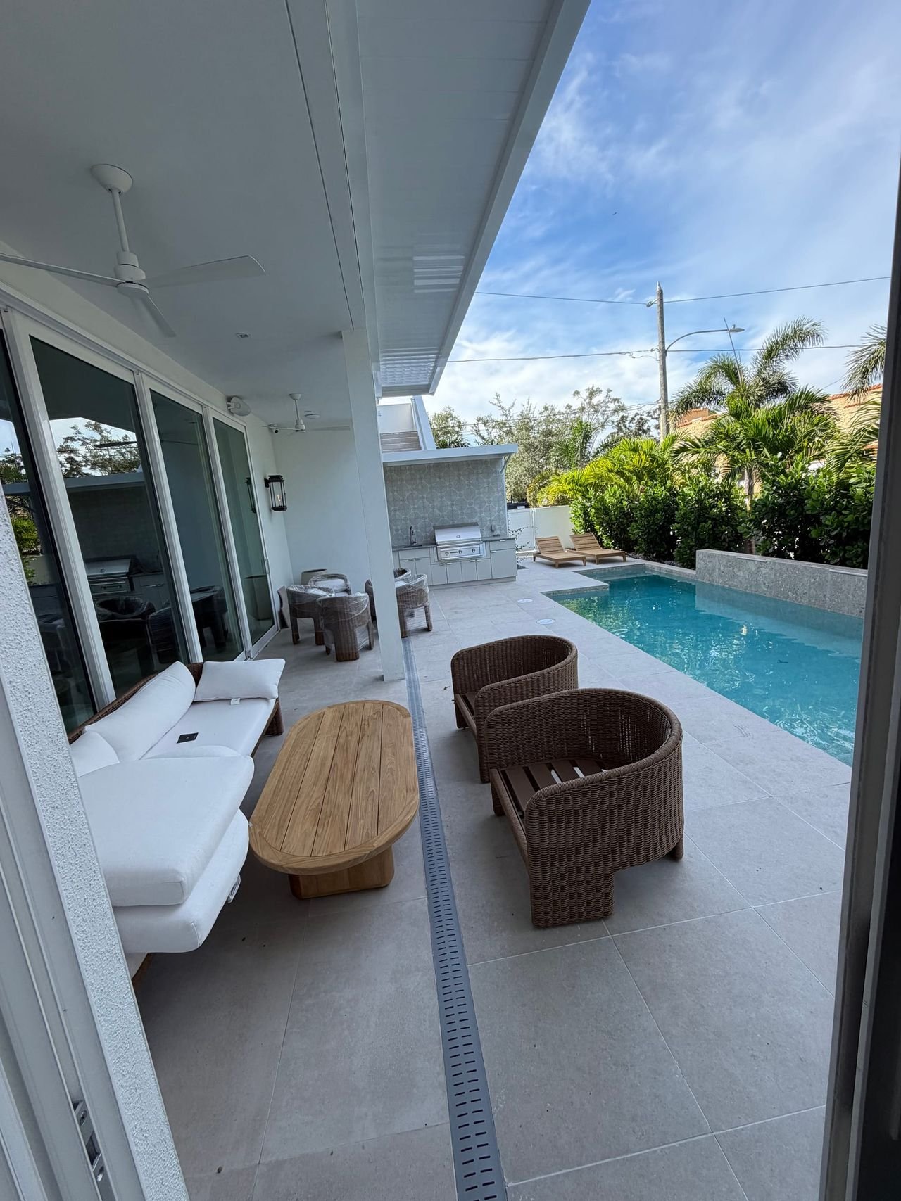 Covered lanai with outdoor kitchen overlooking the pool