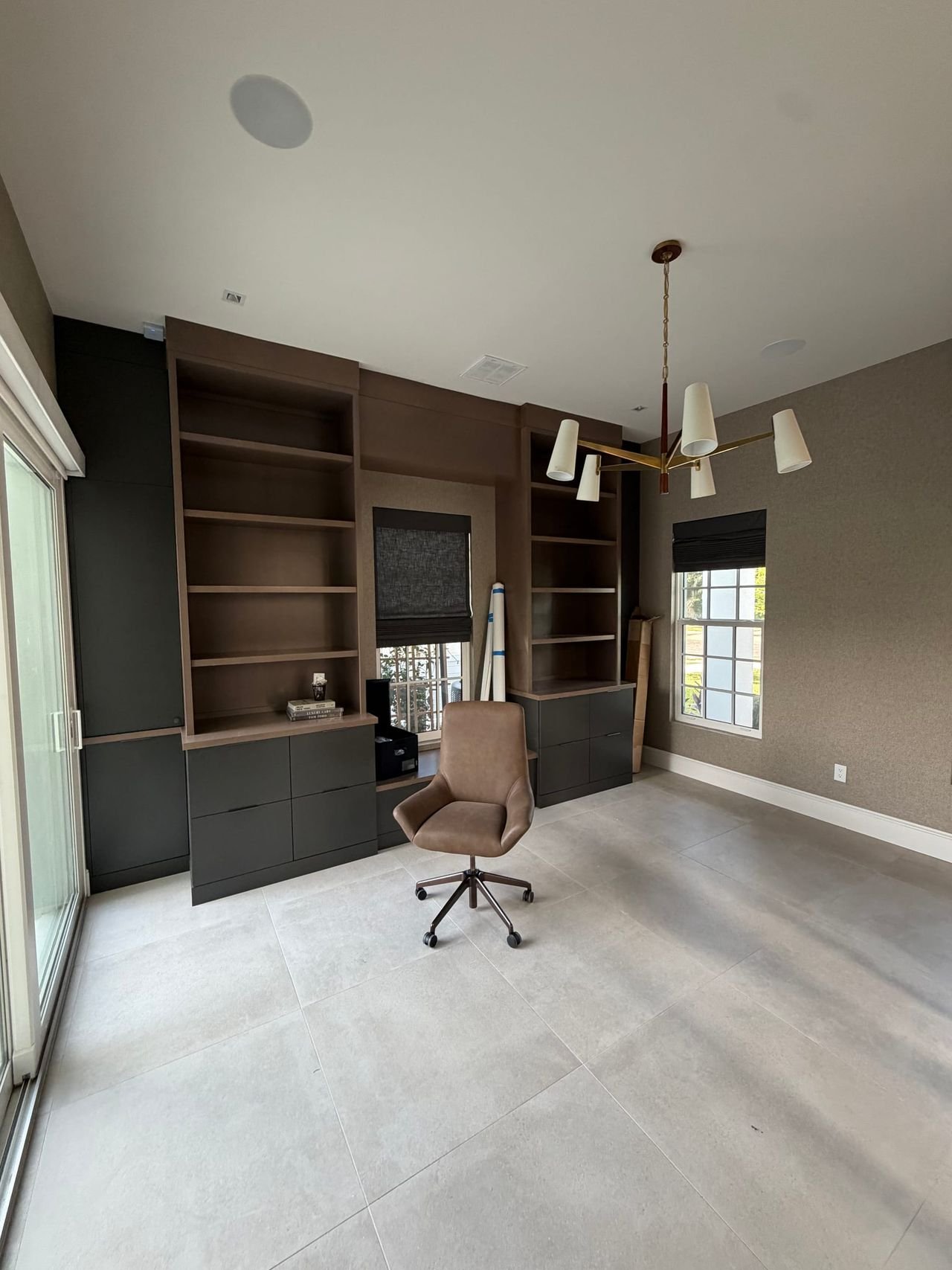 Home office with built-ins and large windows