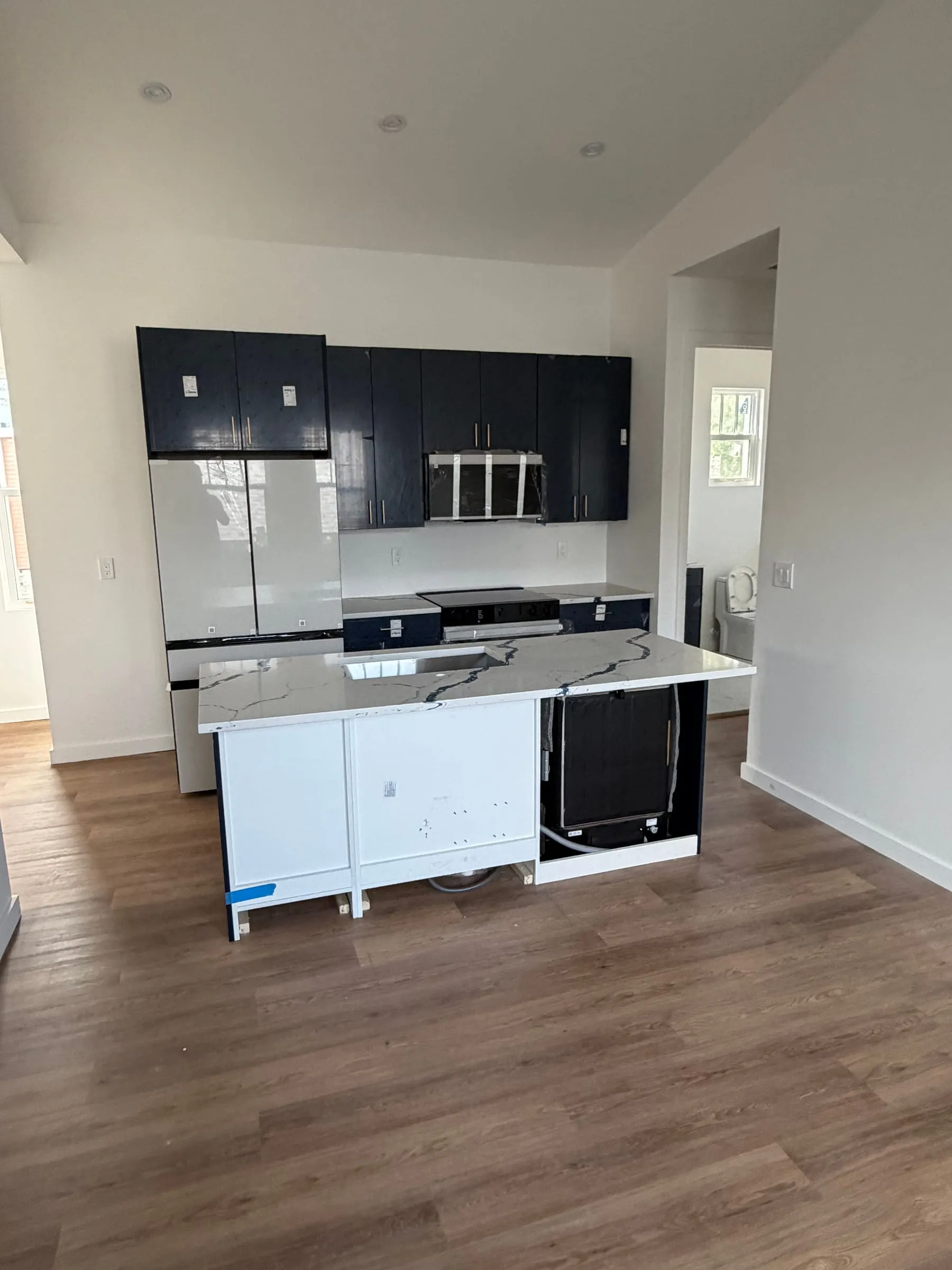 Kitchen with dark cabinets and island during final finishes