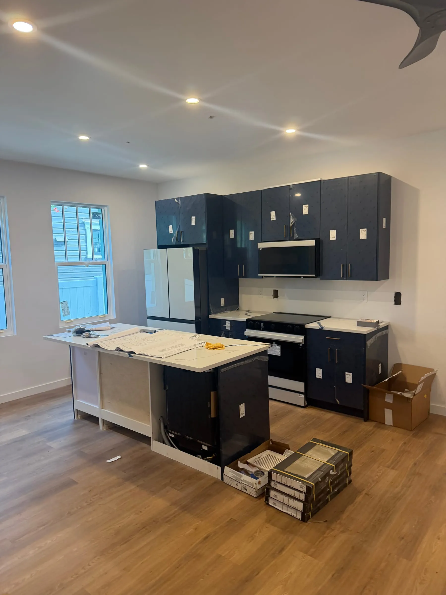 New kitchen with black cabinetry and quartz island