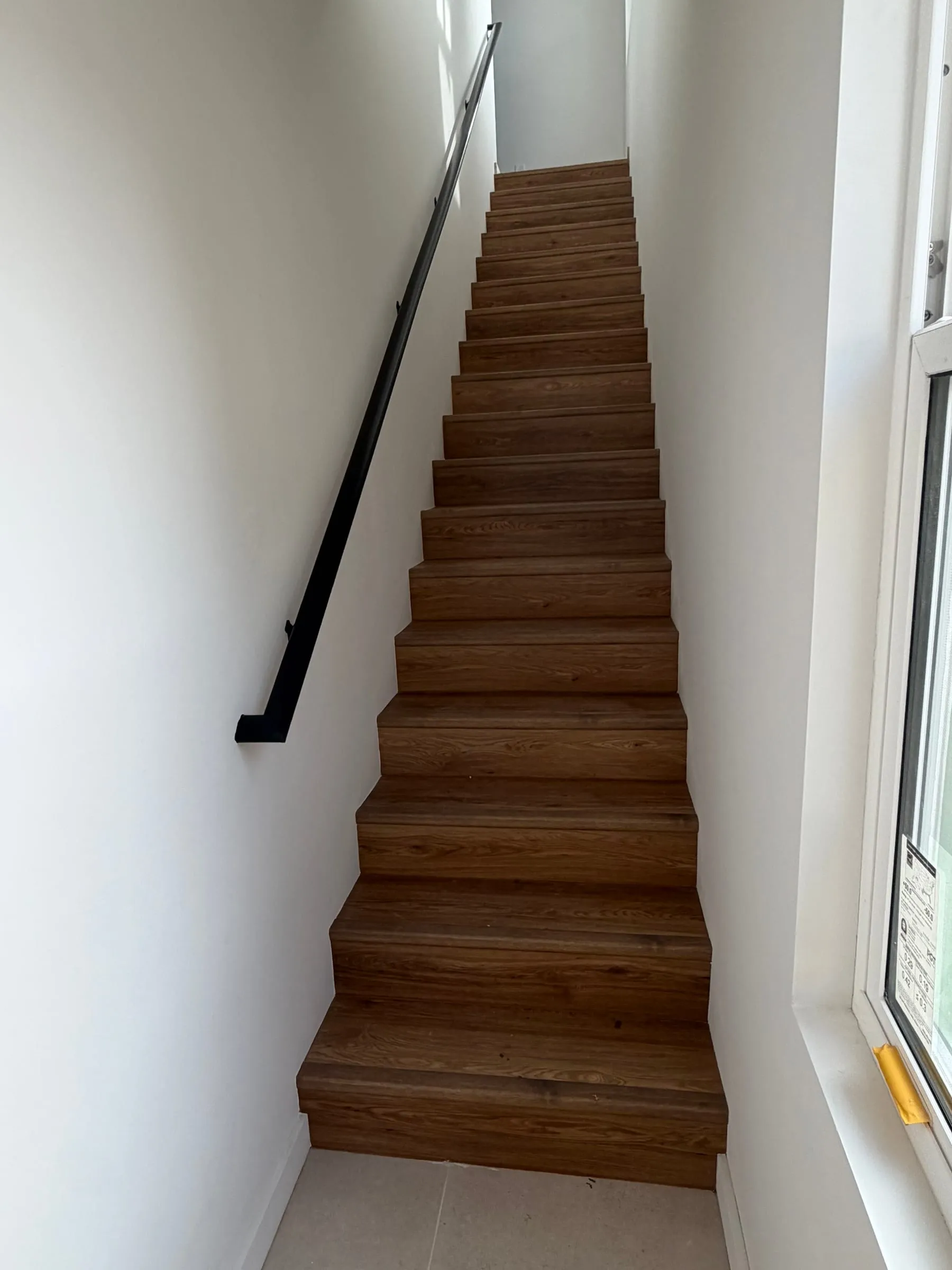 Wood staircase with black handrail