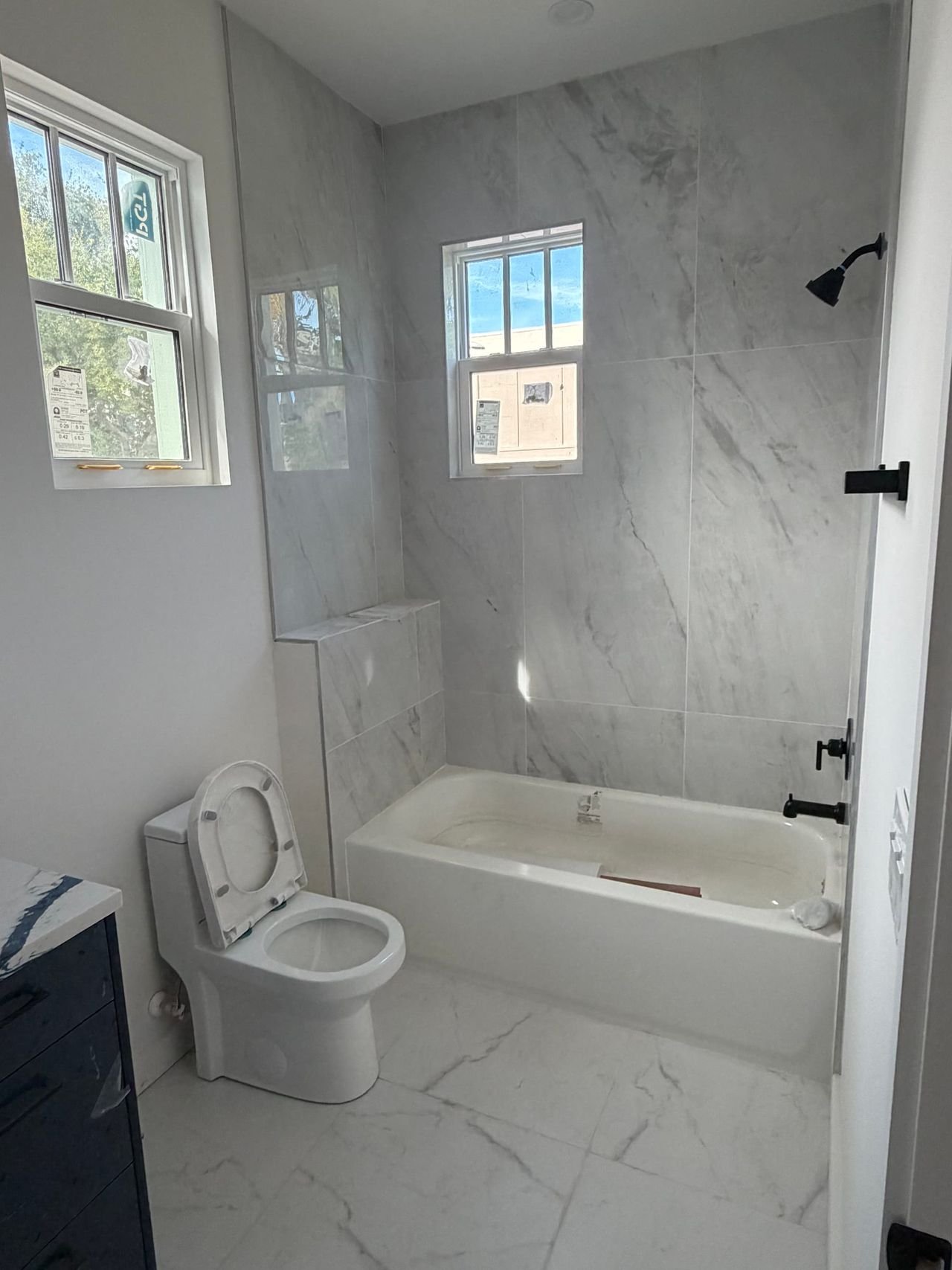 Bathroom with soaking tub and marble-look tile surround